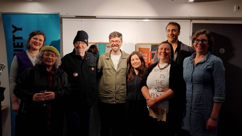 Margate and Folkestone Stanza members on stage at the Poetry Cafe in London with the Poetry Society banner in the background.